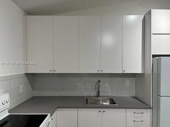 a kitchen with stainless steel appliances white cabinets and a sink