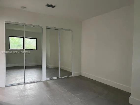an empty room with closet and a window