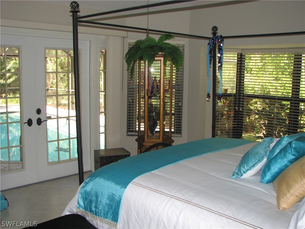 15252 Briar Ridge Circle Fort Myers, FL 33912 - Photo 13 of 25 a bedroom with a large window and a chandelier