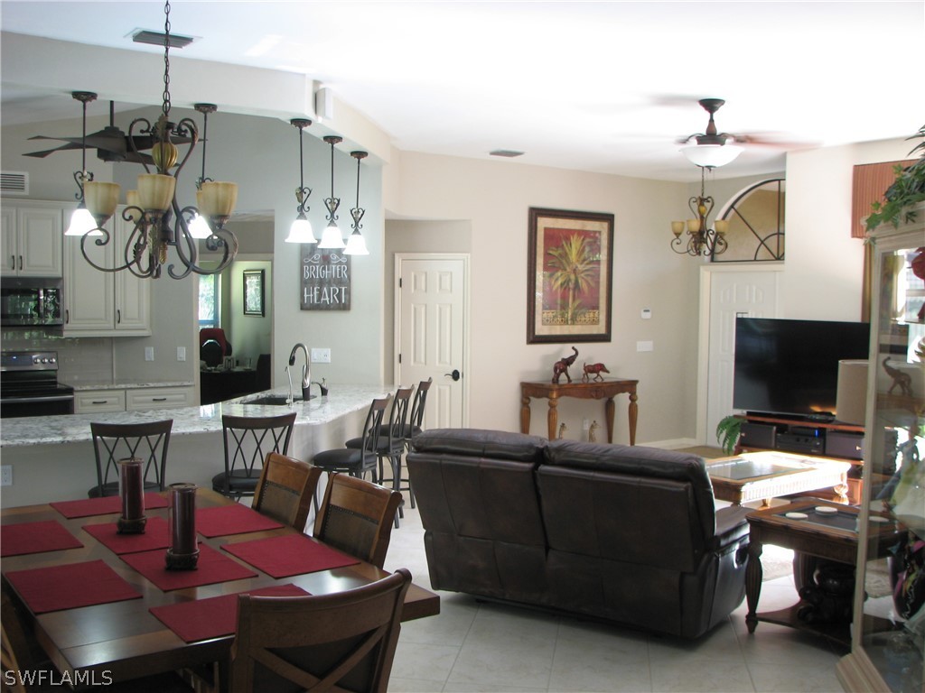 15252 Briar Ridge Circle Fort Myers, FL 33912 - Photo 3 of 25 a living room with furniture a flat screen tv and kitchen view