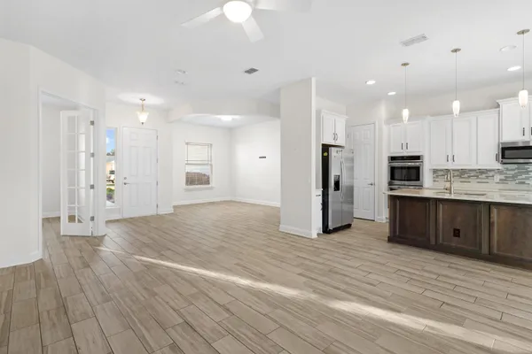 a kitchen with kitchen island granite countertop a sink cabinets and stainless steel appliances