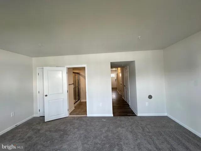 an empty room with closet and mirror
