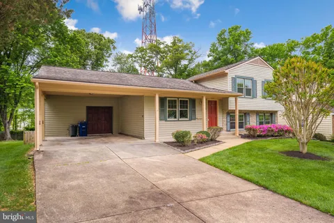 a front view of a house with a yard and trees