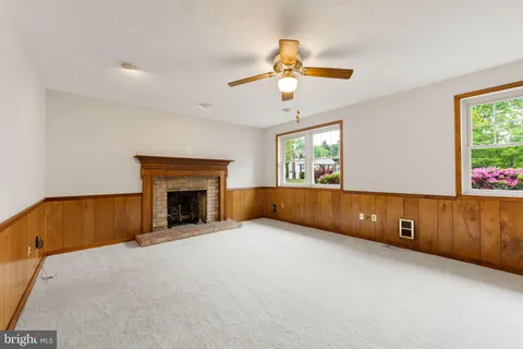 a view of an empty room with a window and a fireplace