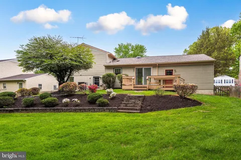 a front view of a house with a garden and trees