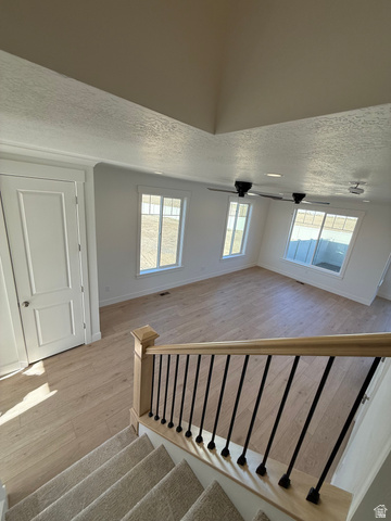 1142 West 220 North Mapleton, UT 84664 - Photo 8 of 26 Stairway with wood finished floors, a textured ceiling, and a ceiling fan