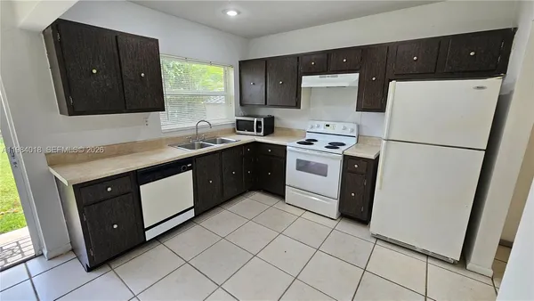 a kitchen with a sink a stove and a refrigerator