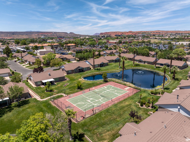 805 South River Road, Unit 70 St. George, UT 84790 - Photo 30 of 38 Community amenities featuring a central pond with fountains, a tennis court, and surrounding green spaces