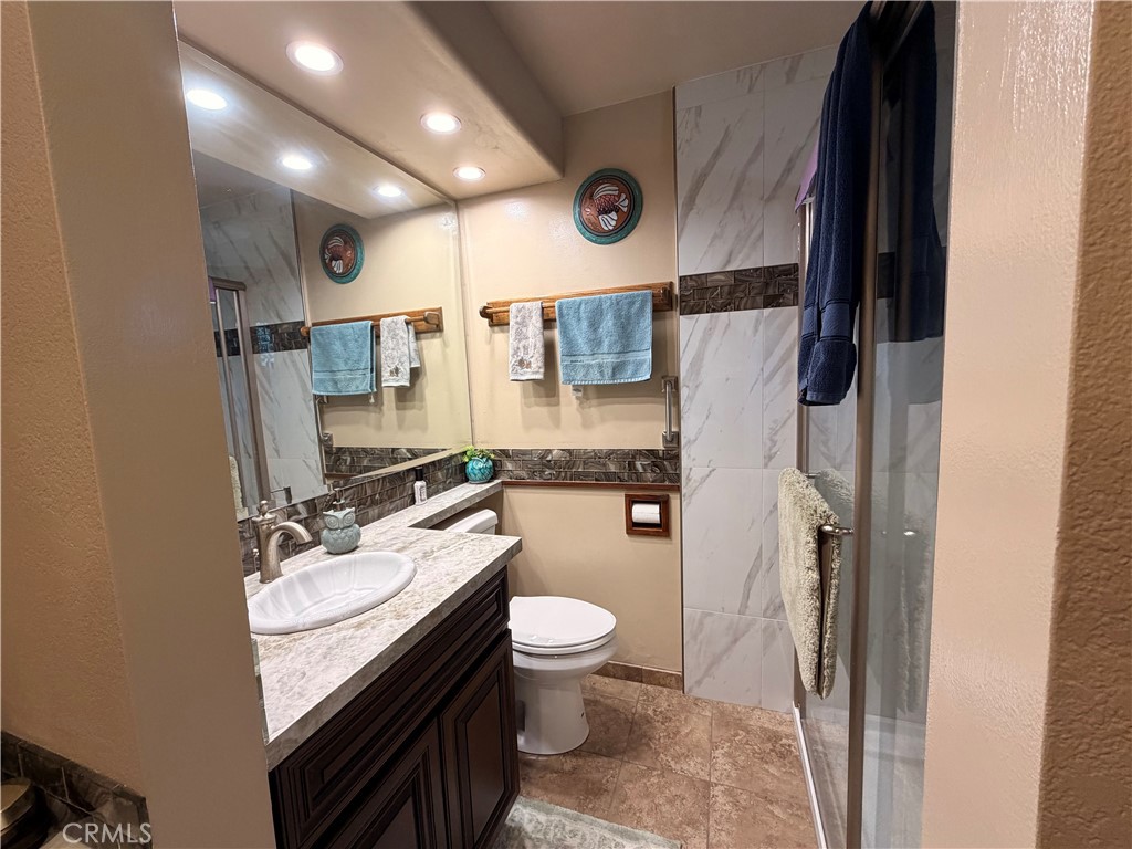 32360 Navajo Road Wildomar, CA 92595 - Photo 13 of 58 a bathroom with a granite countertop sink toilet and shower