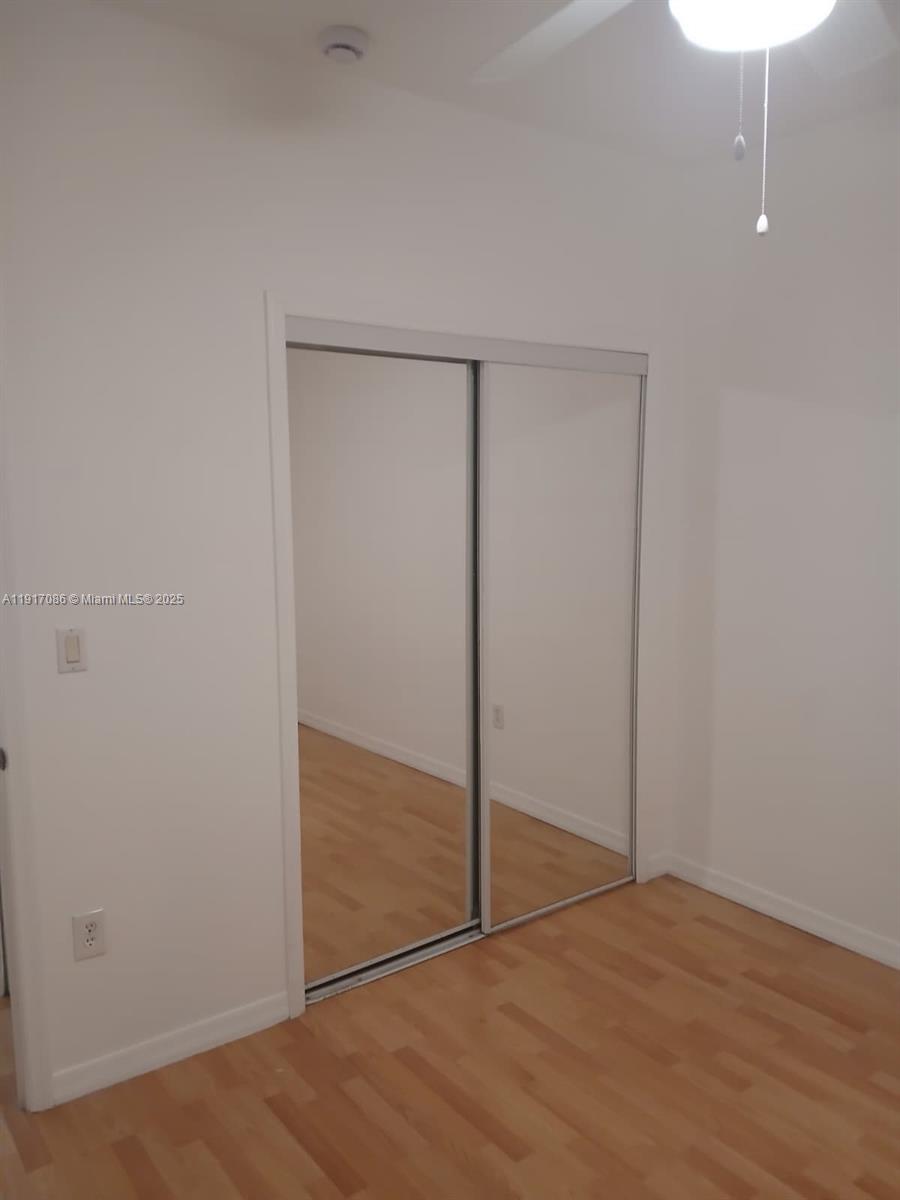 24386 Southwest 109th Court, Unit / Homestead, FL 33032 - Photo 19 of 33 an empty room with wooden floor and door