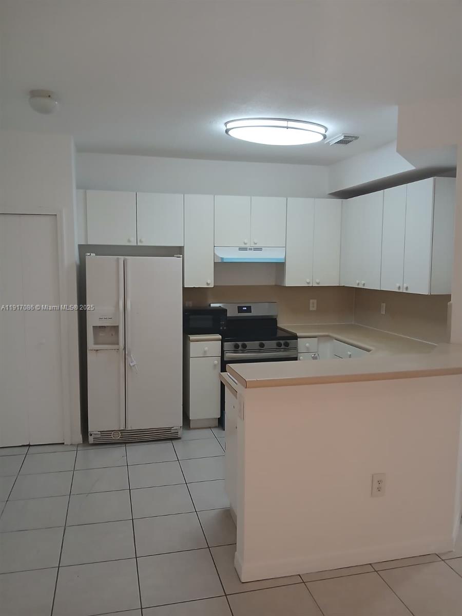 24386 Southwest 109th Court, Unit / Homestead, FL 33032 - Photo 25 of 33 a kitchen with stainless steel appliances granite countertop a refrigerator sink and cabinets