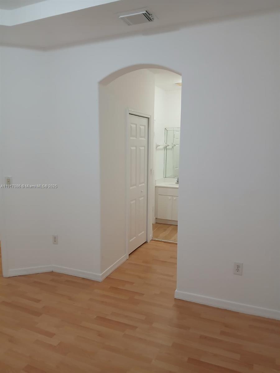 24386 Southwest 109th Court, Unit / Homestead, FL 33032 - Photo 28 of 33 an empty room with wooden floor and mirror