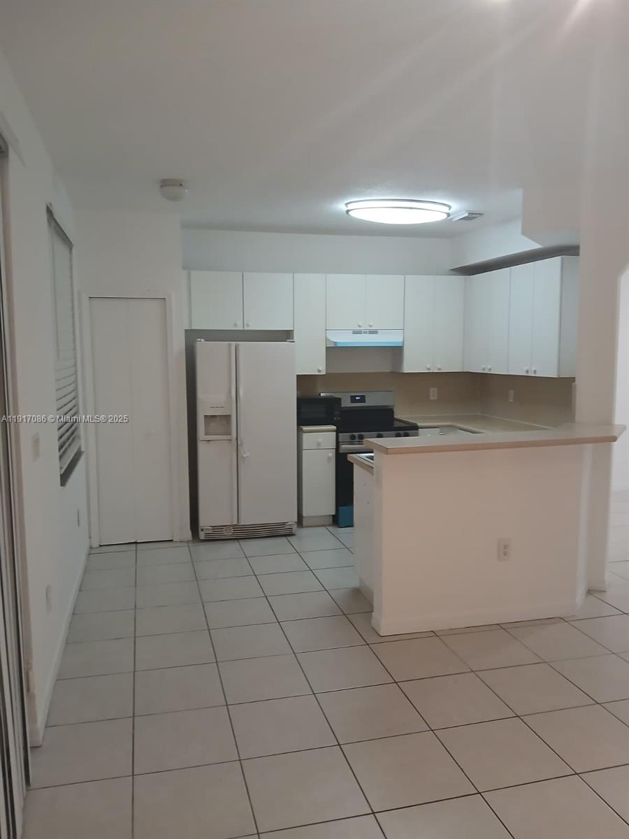 24386 Southwest 109th Court, Unit / Homestead, FL 33032 - Photo 6 of 33 a kitchen with a stove a refrigerator and a sink