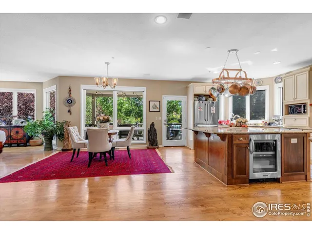 a living room with furniture a chandelier and kitchen view