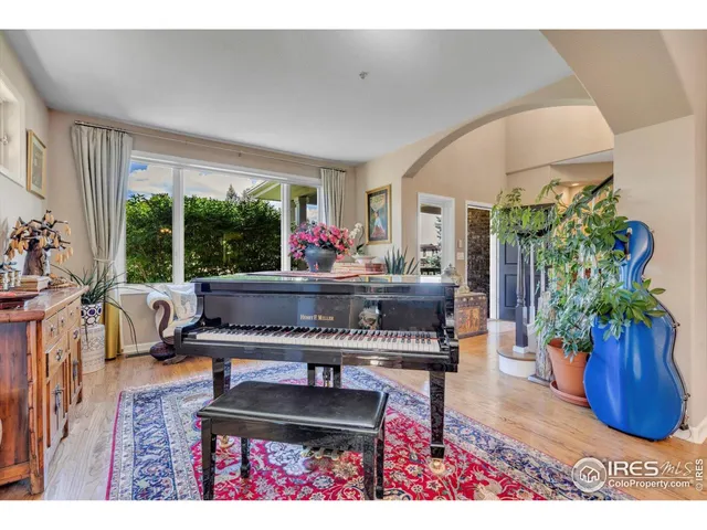 a living room with furniture a potted plant and a large window
