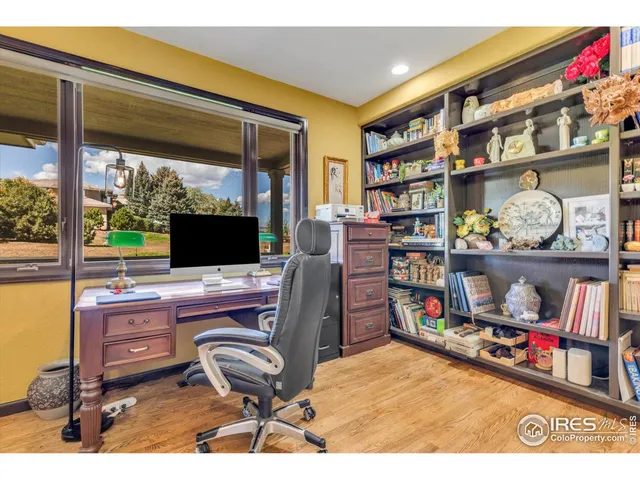 a view of a workspace with furniture and a bookshelf