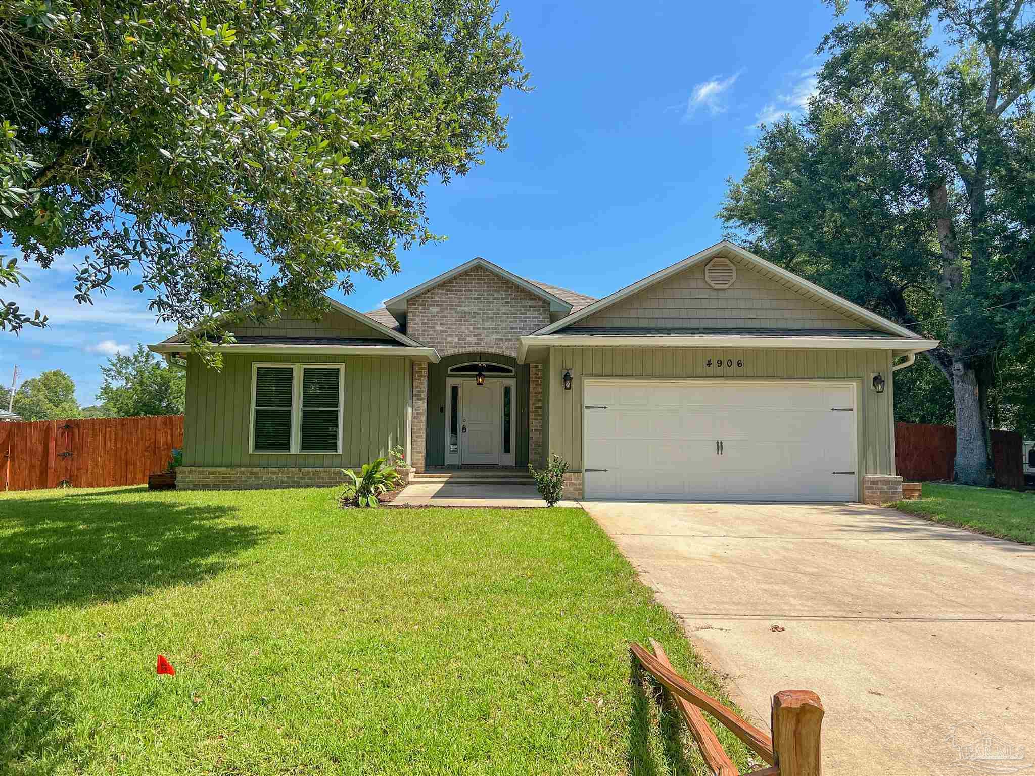 4906 Landmark Lane Pace, FL 32571 - Photo 1 of 34 a front view of a house with yard and trees