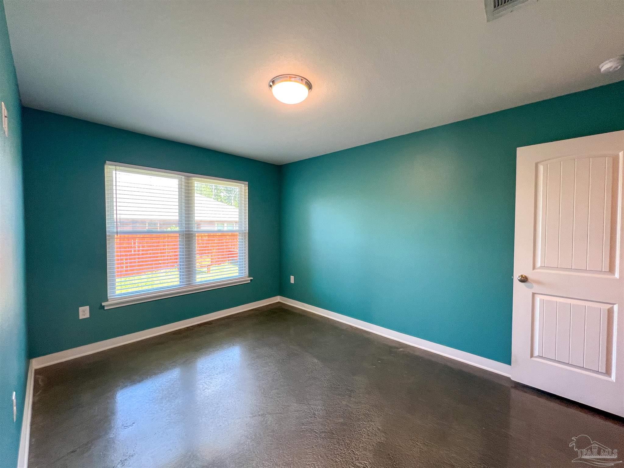 4906 Landmark Lane Pace, FL 32571 - Photo 23 of 34 an empty room with wooden floor and windows