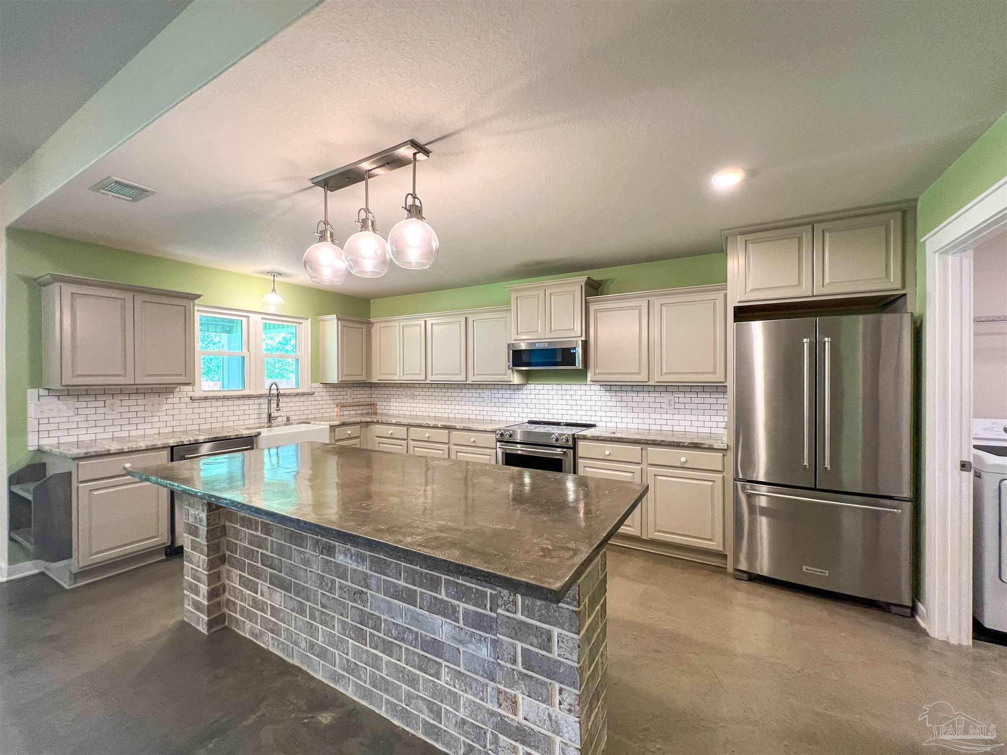 4906 Landmark Lane Pace, FL 32571 - Photo 3 of 34 a kitchen with stainless steel appliances granite countertop a sink stove and refrigerator