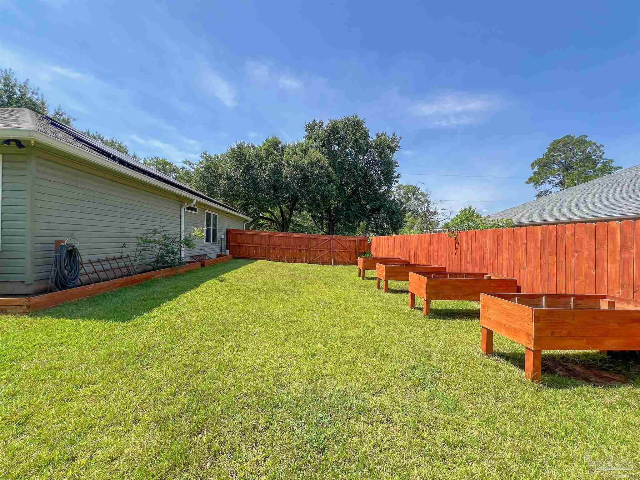 4906 Landmark Lane Pace, FL 32571 - Photo 33 of 34 a backyard of a house with table and chairs