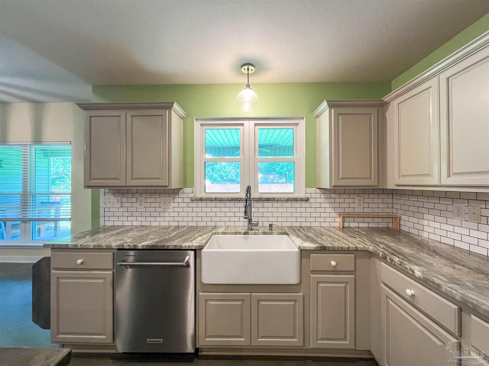 4906 Landmark Lane Pace, FL 32571 - Photo 5 of 34 a kitchen with stainless steel appliances granite countertop a sink a stove and a wooden cabinets