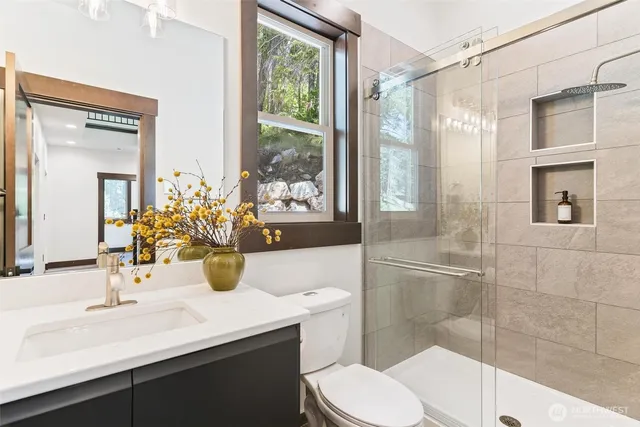 a bathroom with a sink a toilet and shower