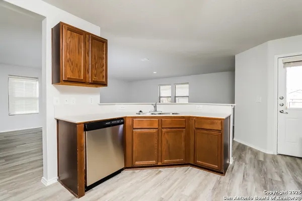 a kitchen with stainless steel appliances granite countertop a sink cabinets and wooden floor
