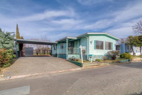 a front view of a house with a yard and outdoor seating