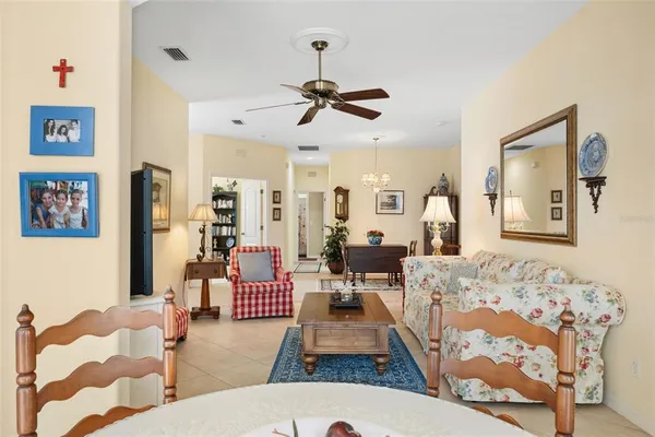 a bedroom with a bed a potted plant on dresser and a chandelier