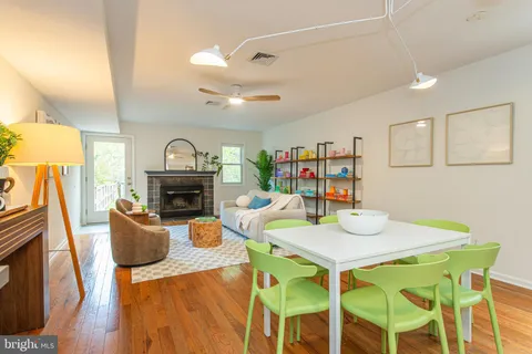 a view of a dining room with furniture a fireplace and wooden floor