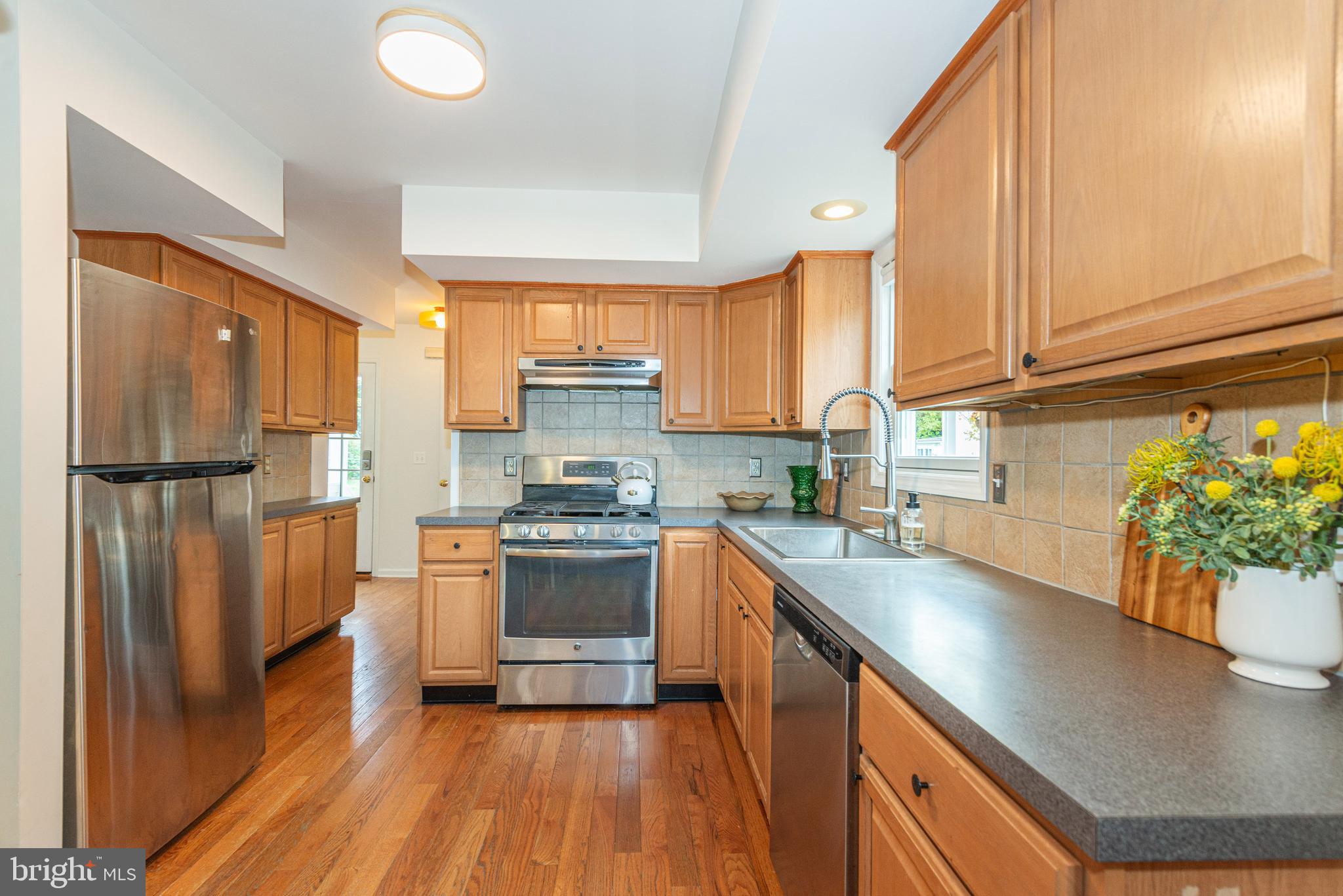 229 South Main Street Pennington, NJ 08534 - Photo 13 of 36 a kitchen with stainless steel appliances granite countertop a sink a stove a refrigerator cabinets and wooden floor