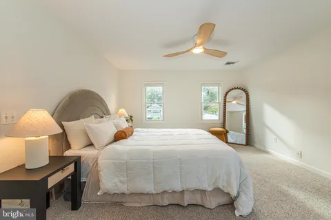 a bedroom with a bed and a large mirror