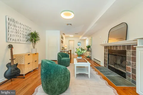a living room with furniture a fireplace and a potted plant