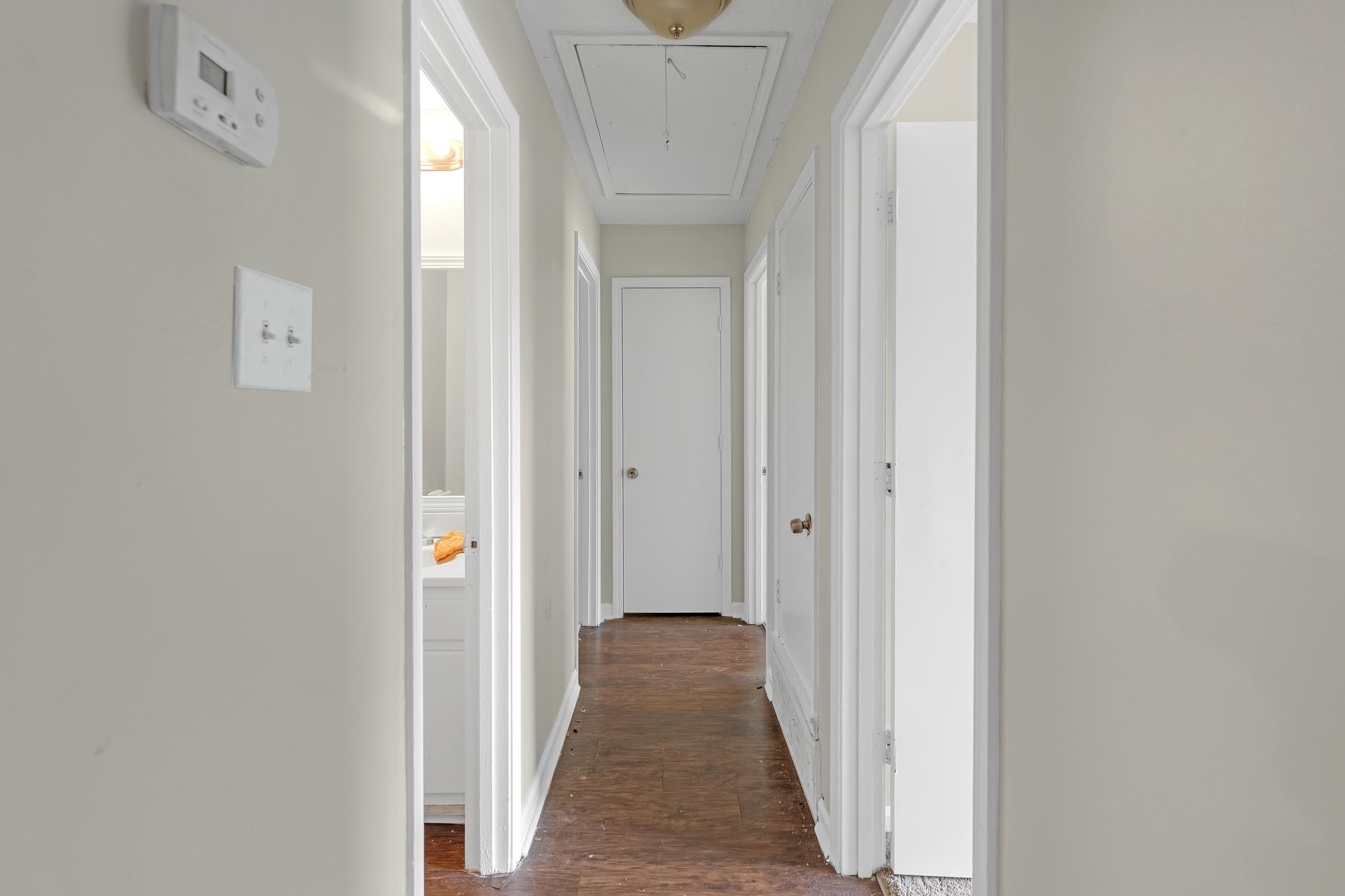 6128 Raintree Drive Memphis, TN 38115 - Photo 15 of 30 a view of a hallway with wooden floor and a bathroom