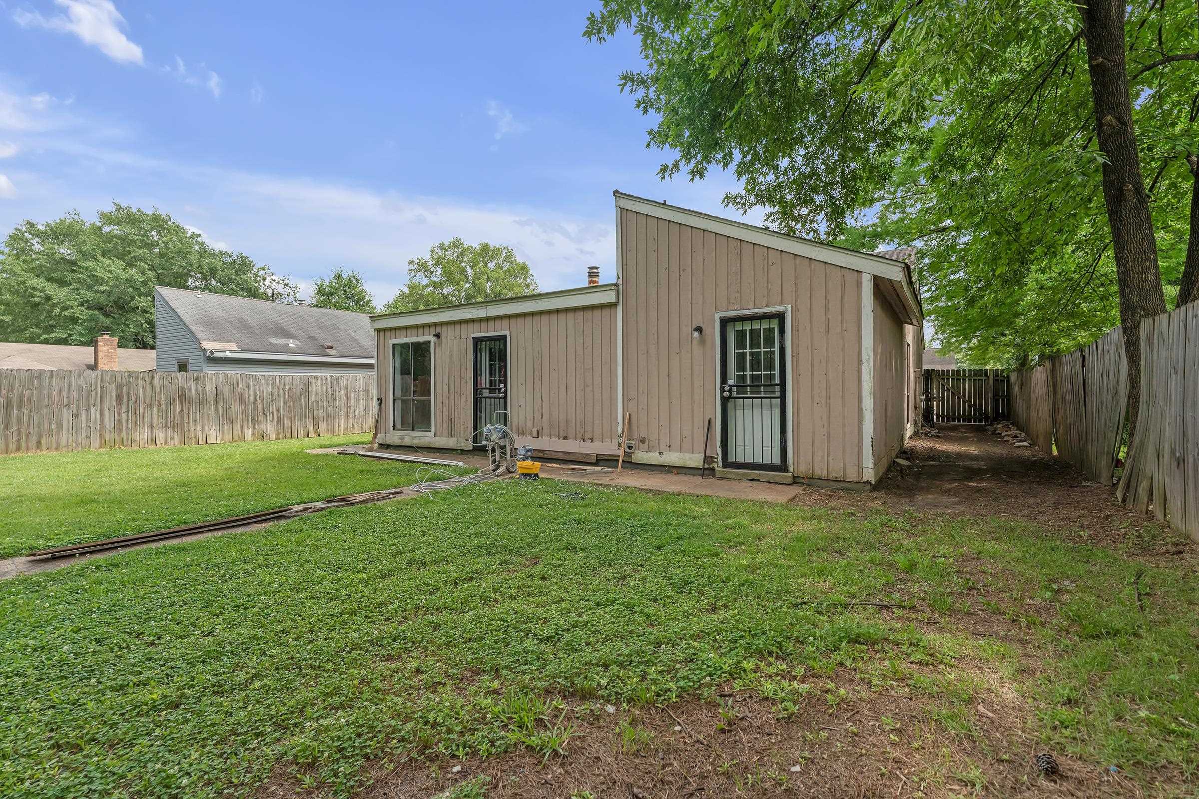 6128 Raintree Drive Memphis, TN 38115 - Photo 26 of 30 a backyard of a house with plants and large tree