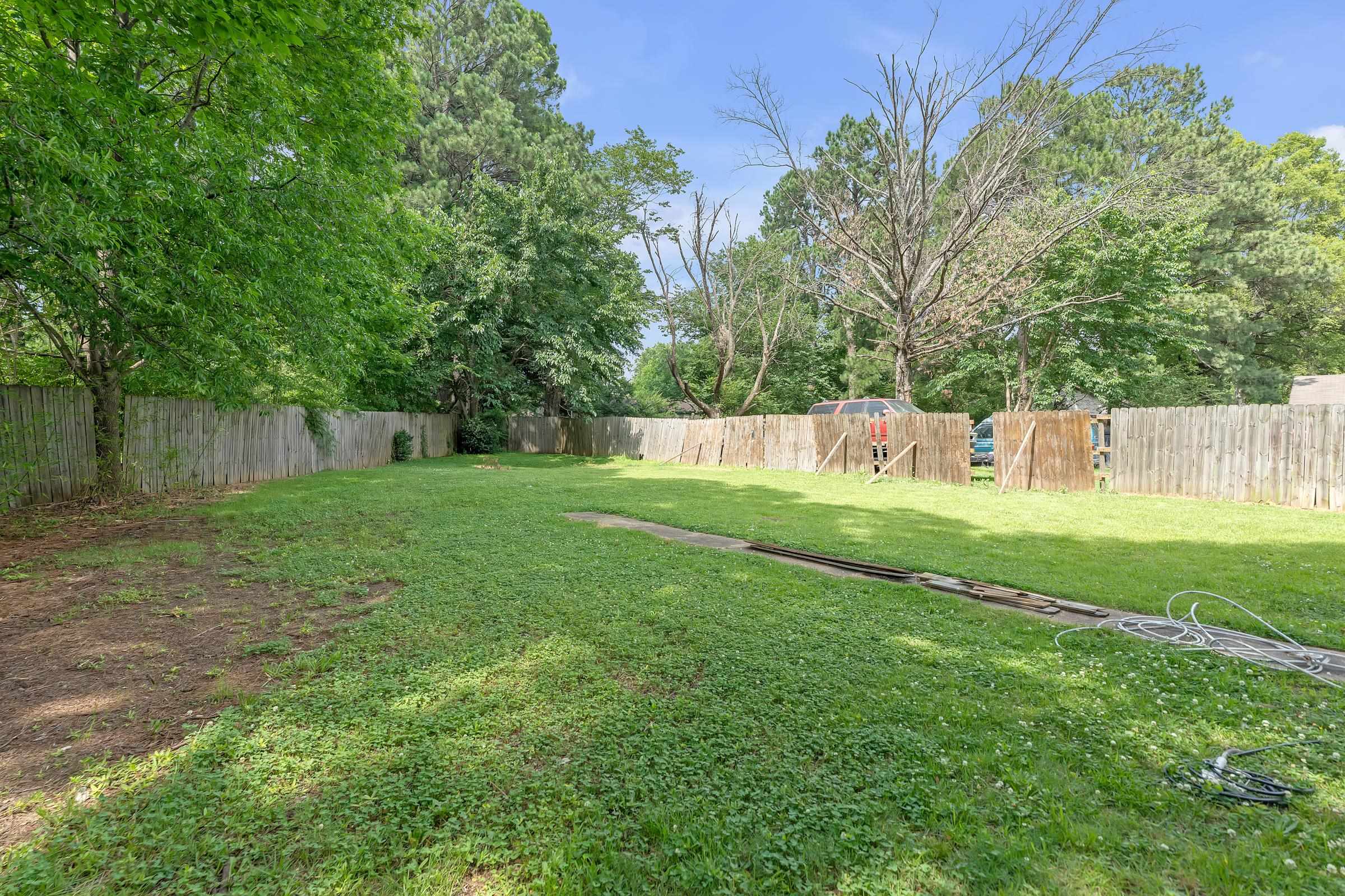 6128 Raintree Drive Memphis, TN 38115 - Photo 27 of 30 a view of a park with large trees and a wooden fence