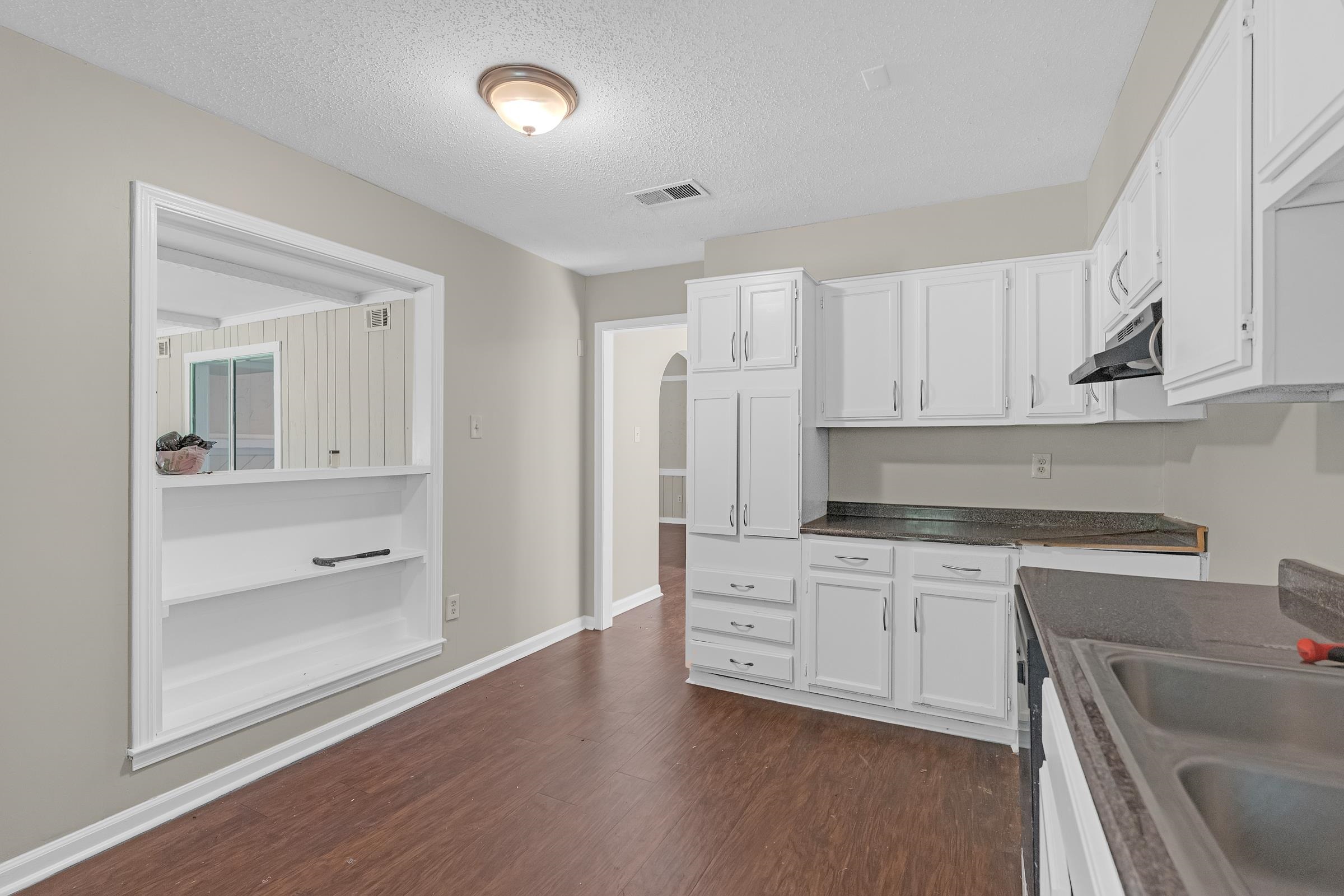 6128 Raintree Drive Memphis, TN 38115 - Photo 10 of 30 a kitchen with a sink cabinets and wooden floor