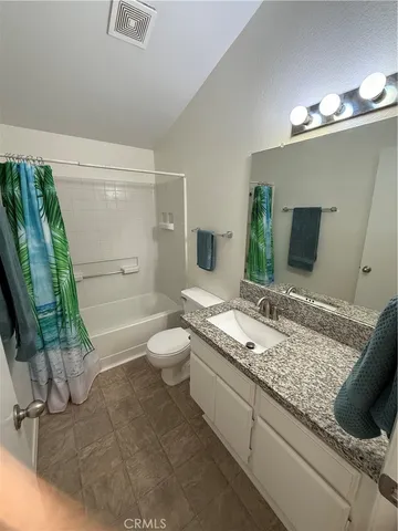a bathroom with a granite countertop sink a toilet and bathtub