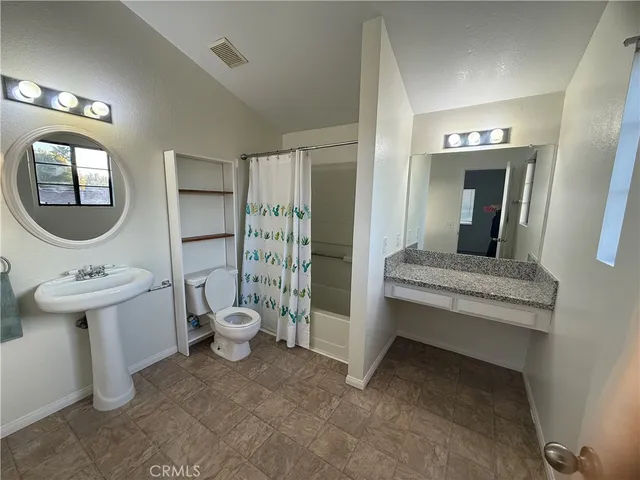 a bathroom with a toilet a sink and mirror