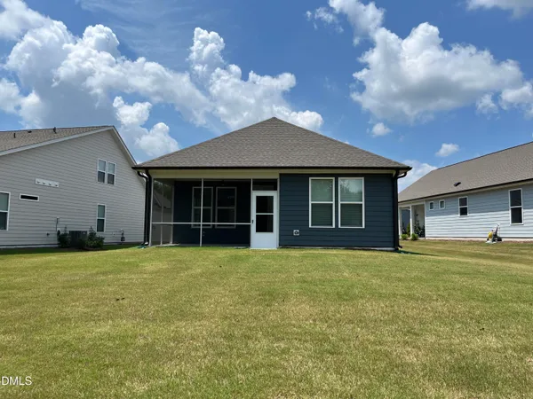 a view of a house with a yard and a large tree