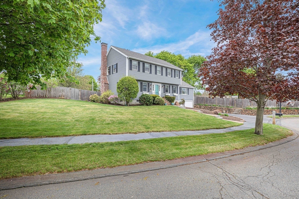 a view of a house with a big yard and large trees