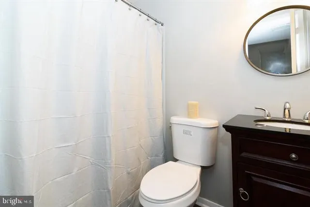 a bathroom with a toilet a sink and vanity