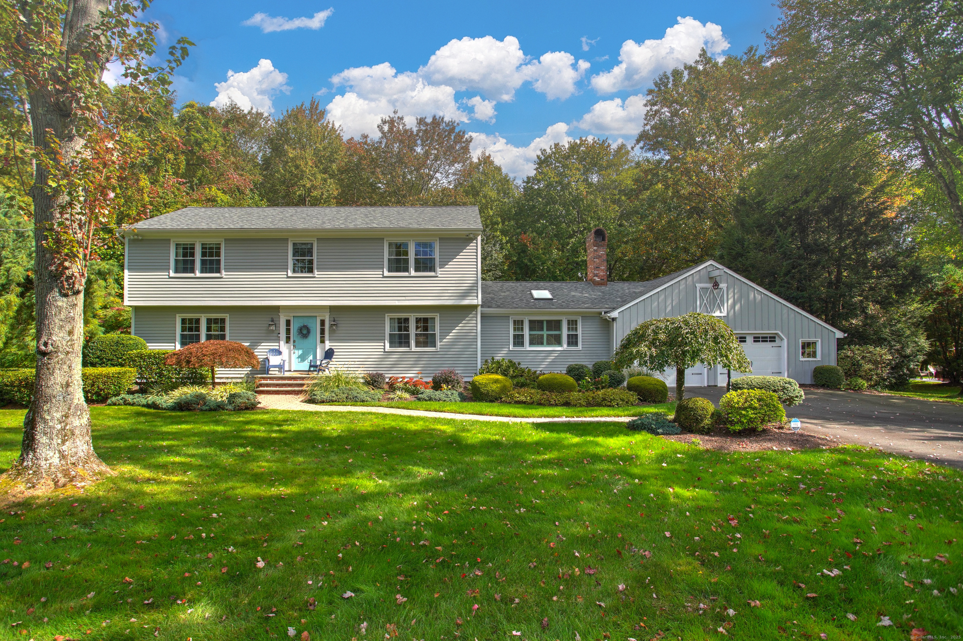 a front view of a house with a garden and trees