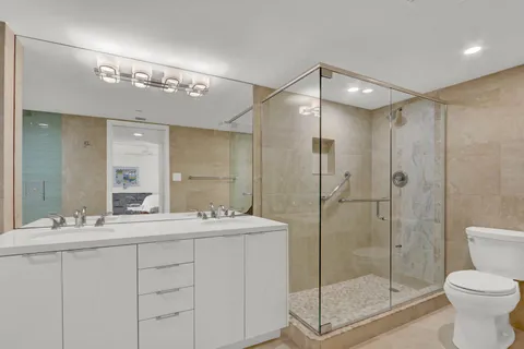 a bathroom with a shower sink mirror and toilet