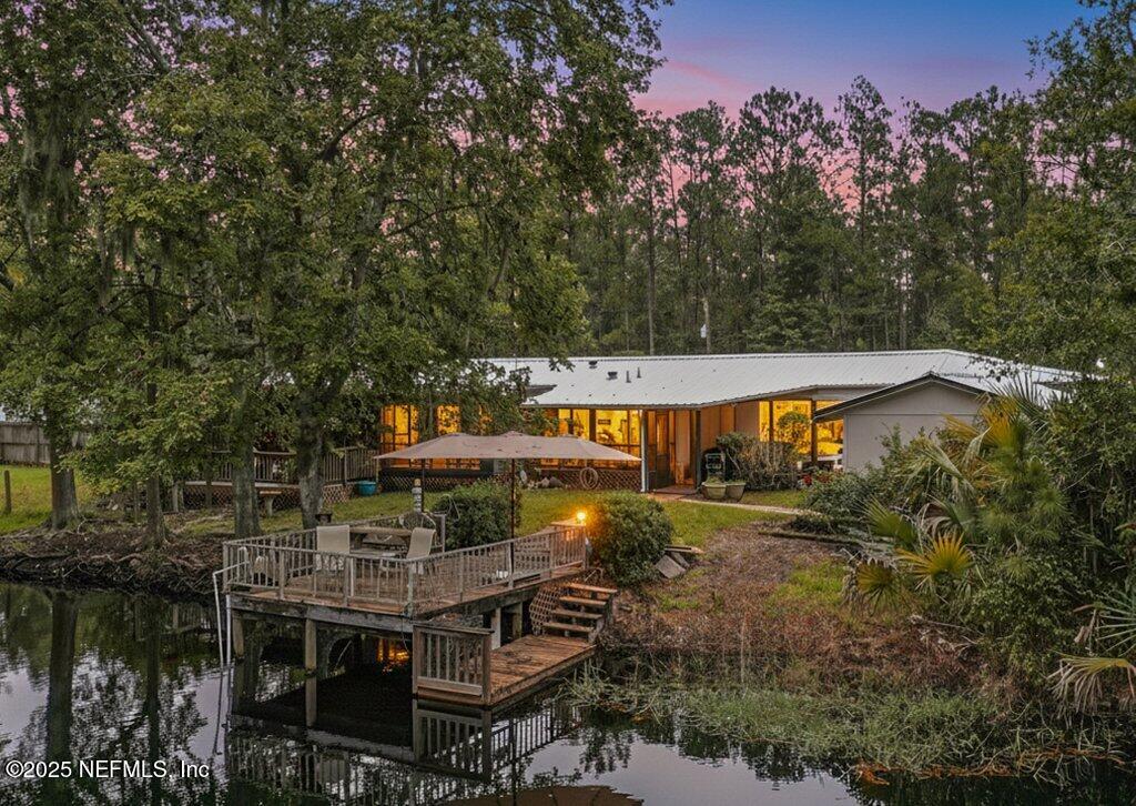 an aerial view of a house with swimming pool and large trees