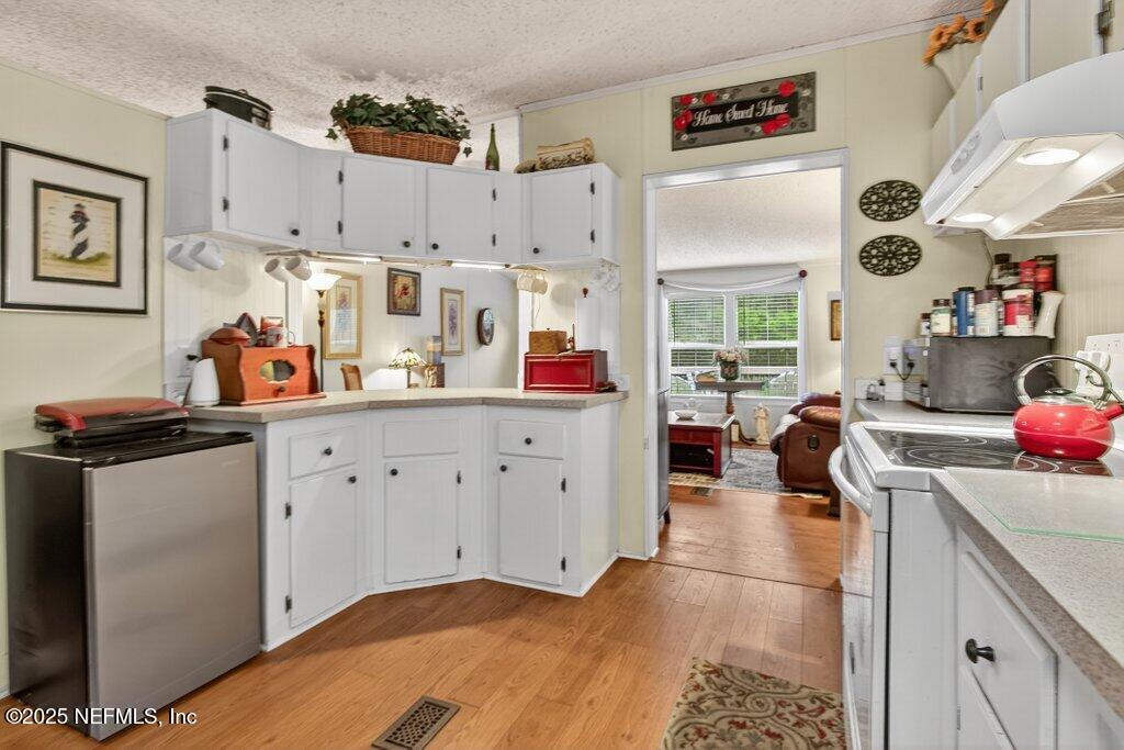 695 Carlin Road Satsuma, FL 32189 - Photo 11 of 53 a kitchen with white cabinets and window