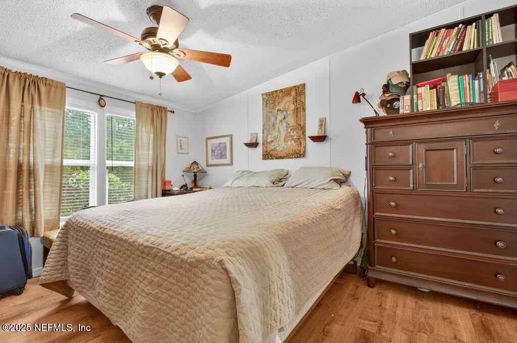 695 Carlin Road Satsuma, FL 32189 - Photo 20 of 53 a spacious bedroom with a bed a dresser and a book shelf