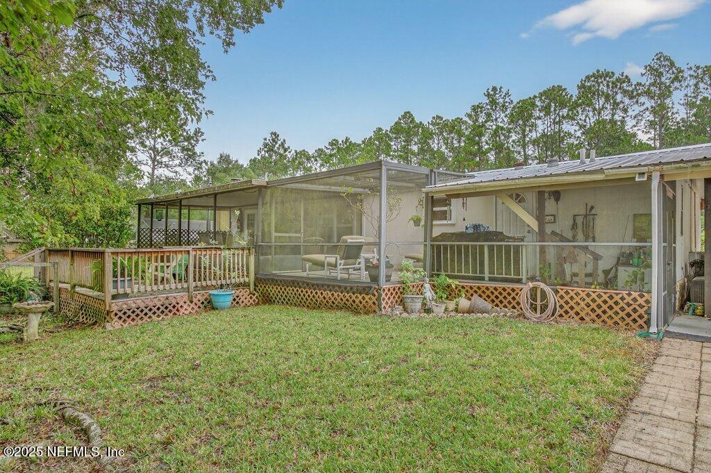695 Carlin Road Satsuma, FL 32189 - Photo 32 of 53 a view of a deck with a floor to ceiling window and wooden fence