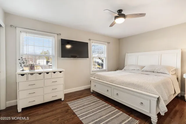 a bedroom with a large bed and a flat tv screen on dresser
