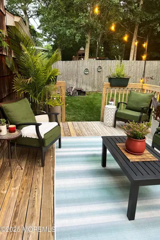 a view of a patio with table and chairs couches with wooden floor and fence